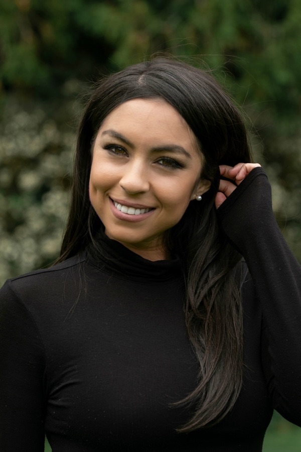Elisenda Asencio-MacMartin smiling outdoors near greenery in San Francisco, California
